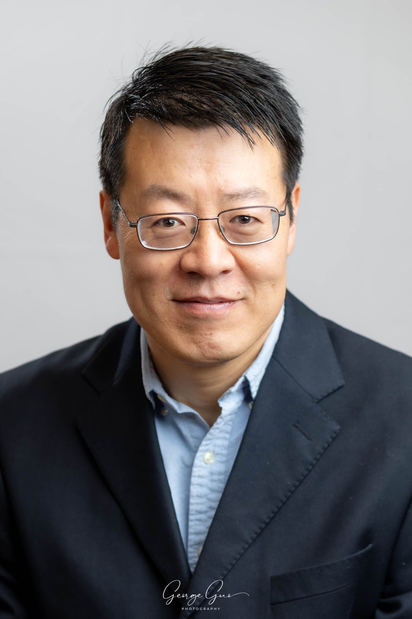 Professional headshot of a man wearing a suit, captured in a studio lighting setup by George Guo Photographer