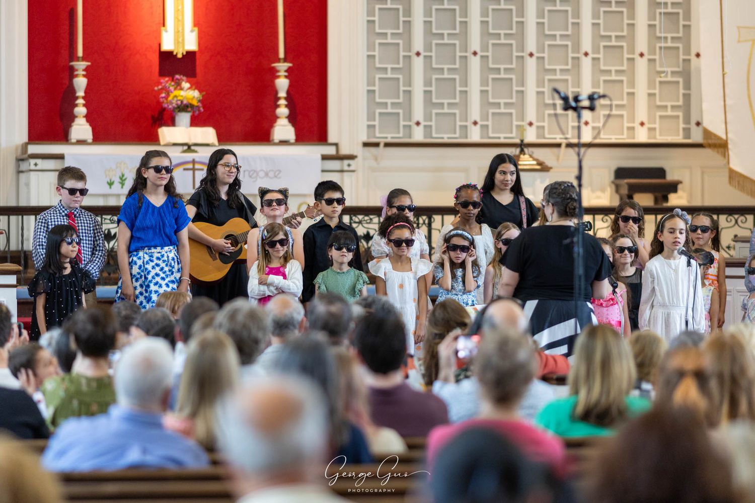 A group of children performing on stage at a church concert, photographed by George Guo Photographer