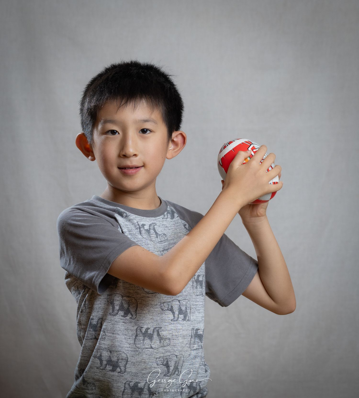 a young boy playing ball during a studio portrait session, captured by George Guo Photographer