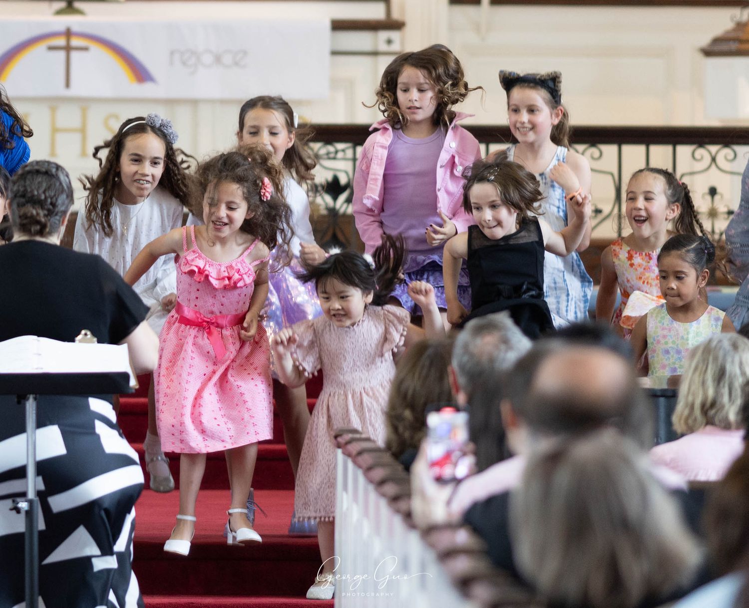 A group of children dancing and performing on stage at a church concert, photographed by George Guo Photographer