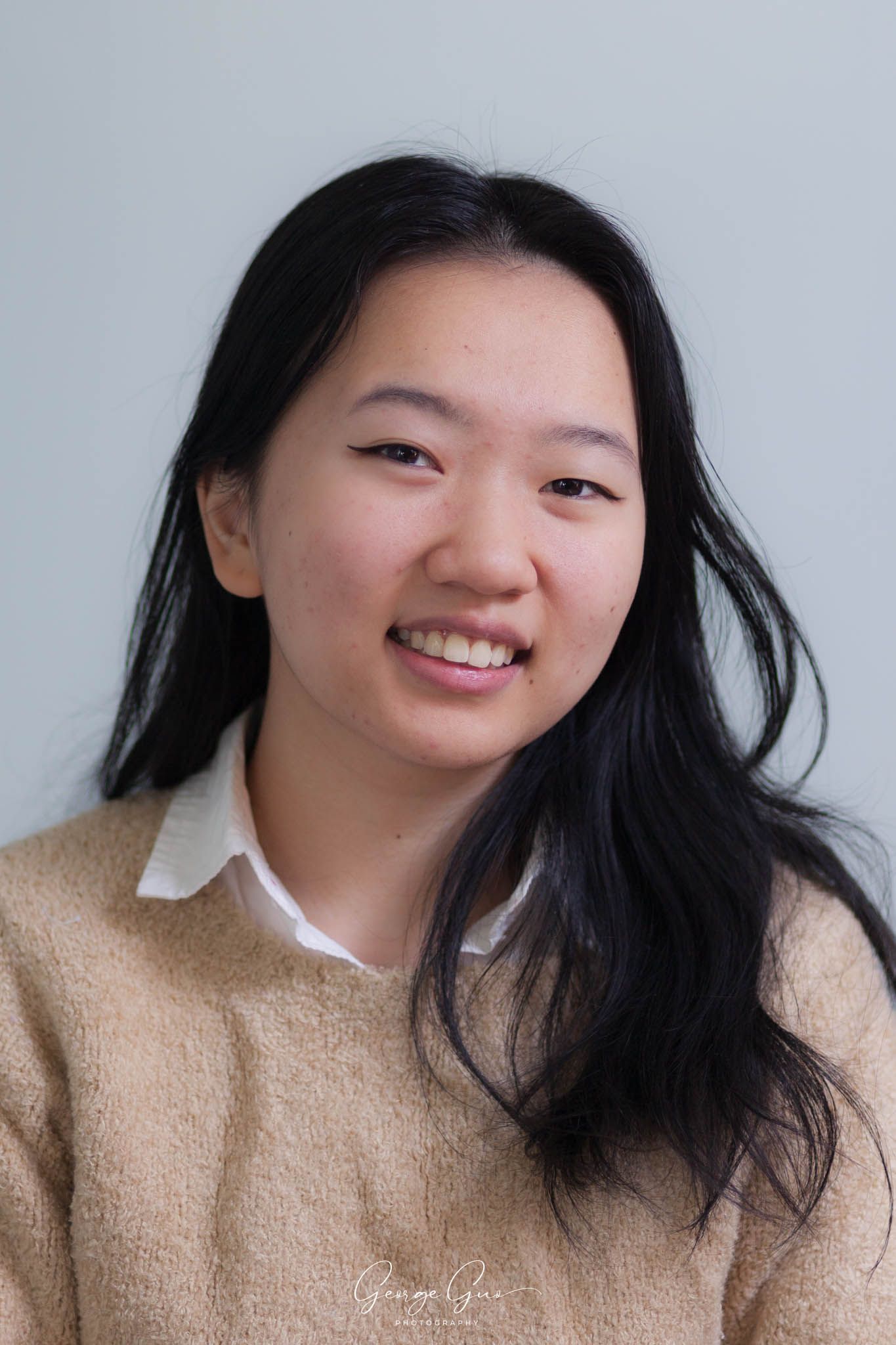 Professional headshot of a young lady wearing a shirt, captured in a studio lighting setup by George Guo Photographer
