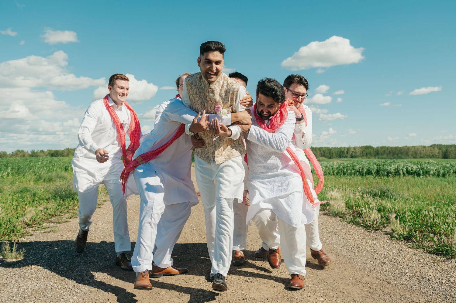 groomsmen tackling groom during hindu Indian wedding