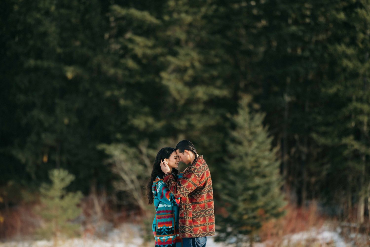couple in forest during wintertime embracing each other