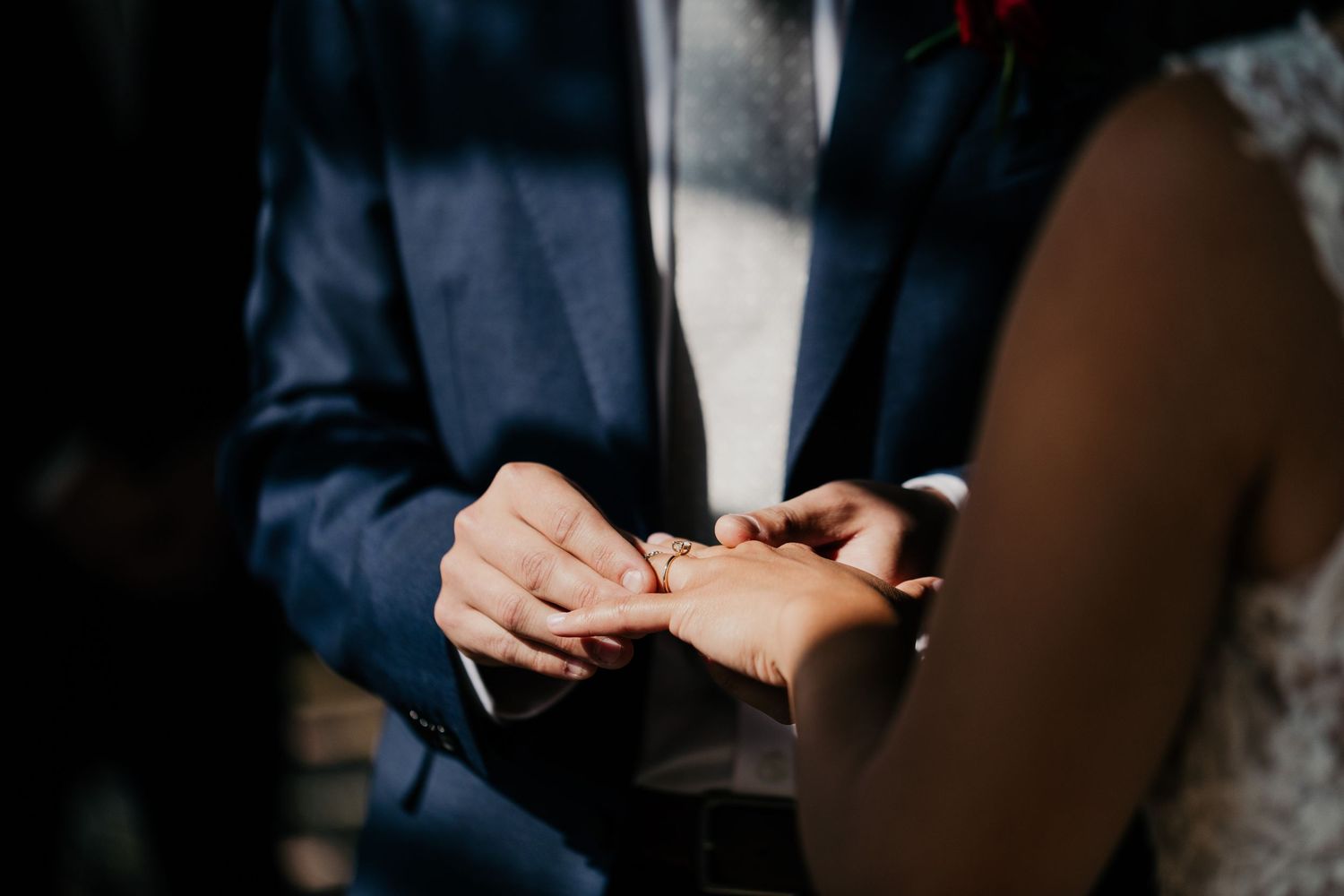 groom putting on brides ring during ceremony