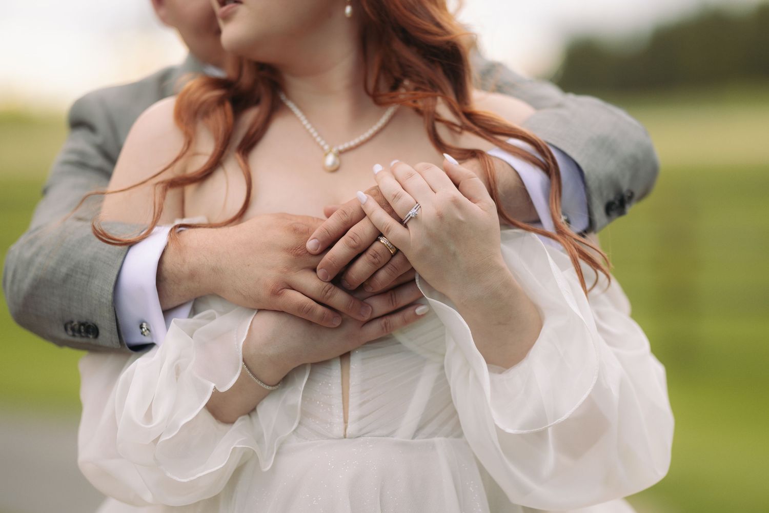 wedding couple embracing and showing rings