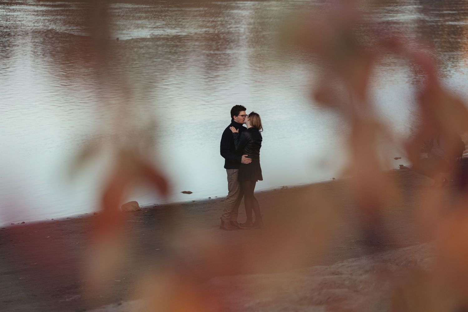 couple photographed through fall leaves