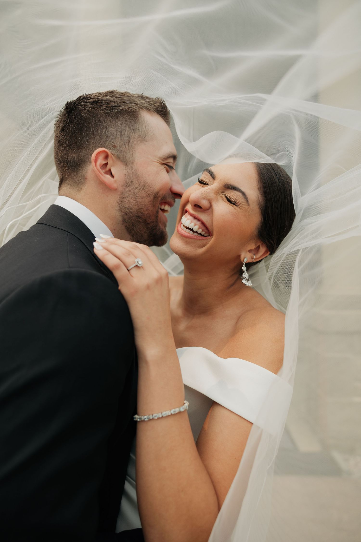Edmonton wedding portrait featuring veil movement and natural couple interaction.