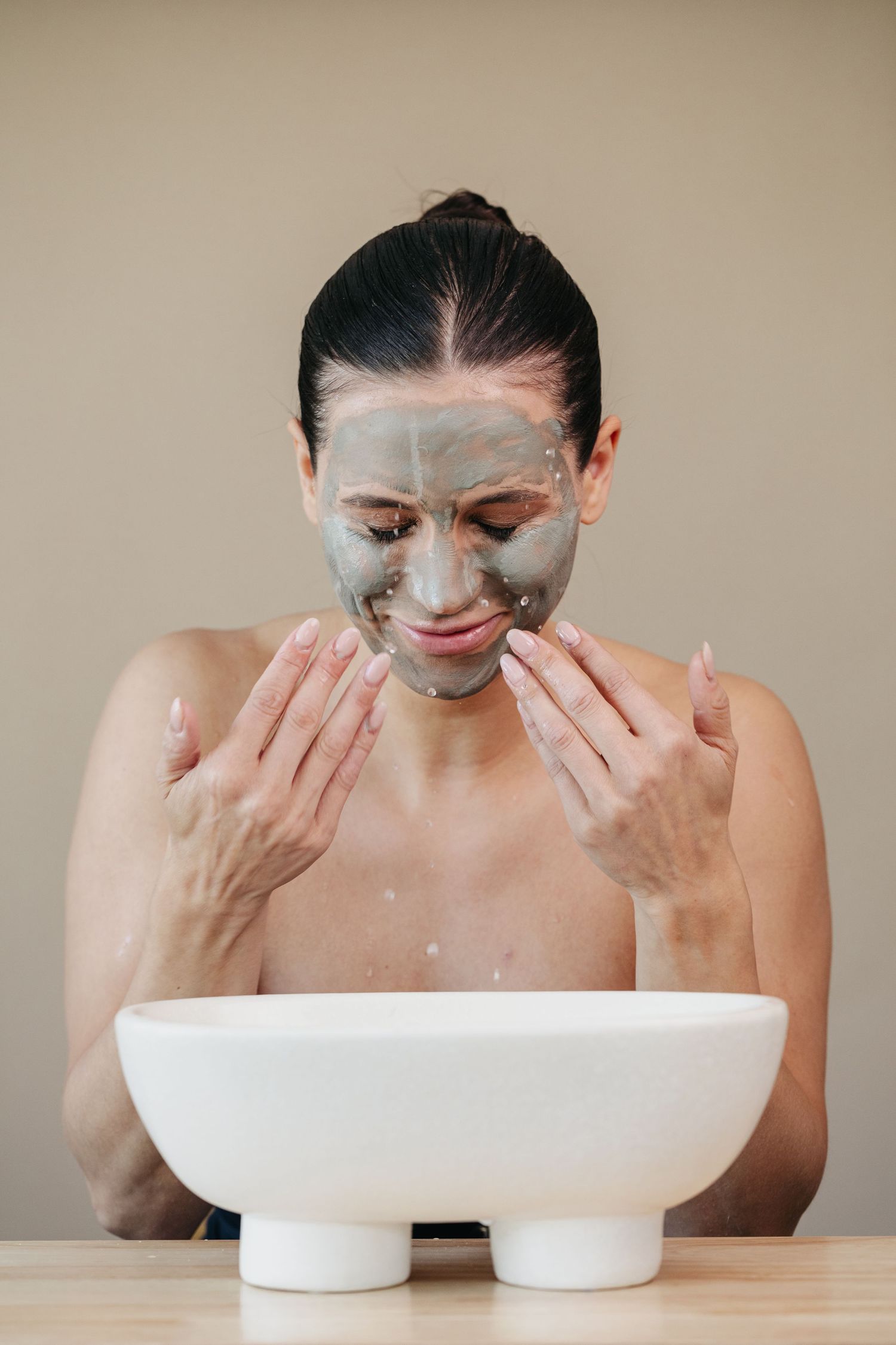 Studio branding photographer in Edmonton capturing model smashing water for skin care brand, captured by Marcu fotography
