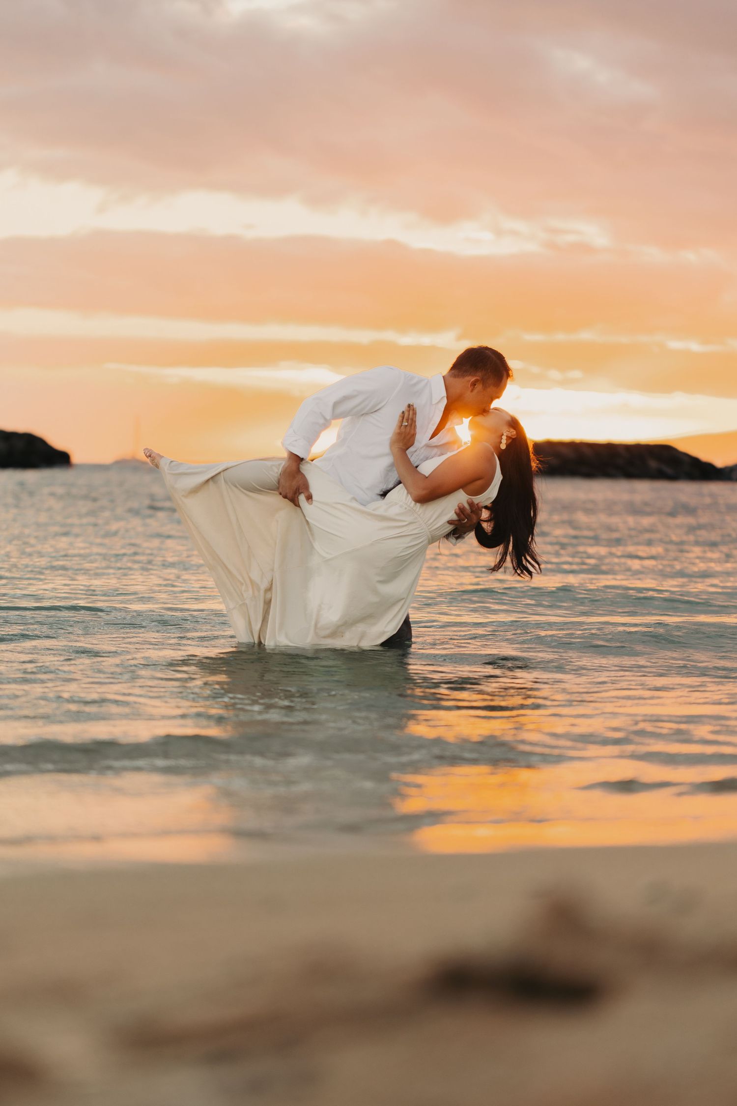 couple kissing and dipping in Hawaii waters