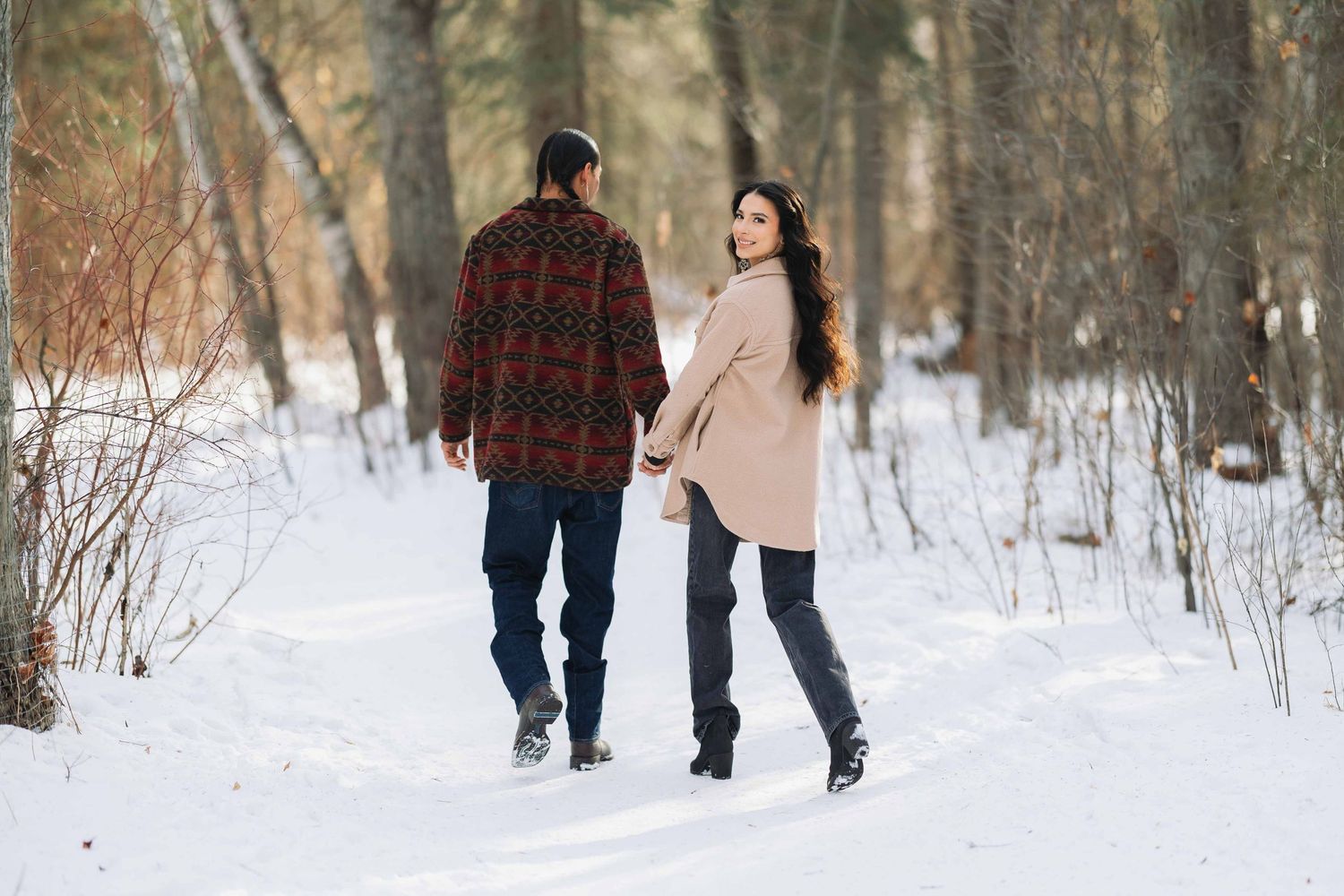 couple in forest during wintertime embracing each other