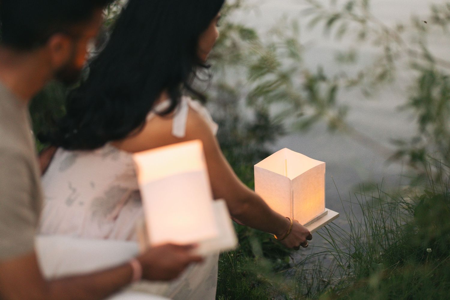 couple putting lanterns in water during lantern festival in edmonton