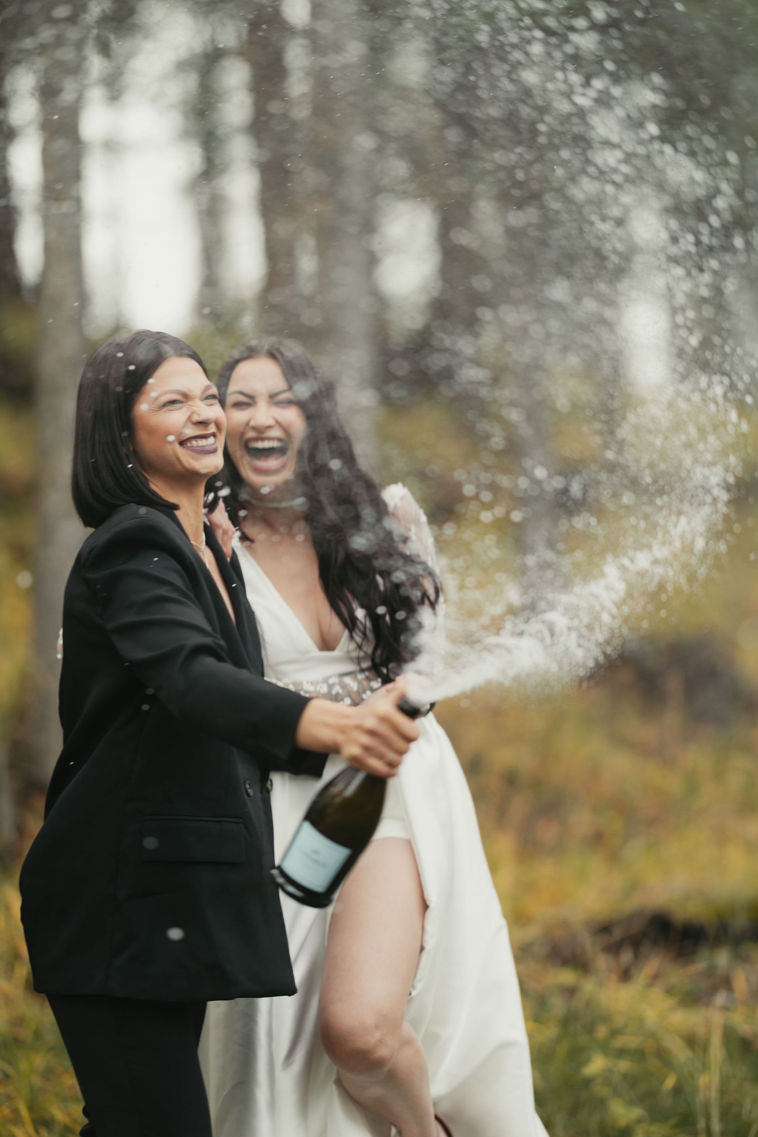 Banff wedding photographer capturing champagne celebration during an outdoor wedding.