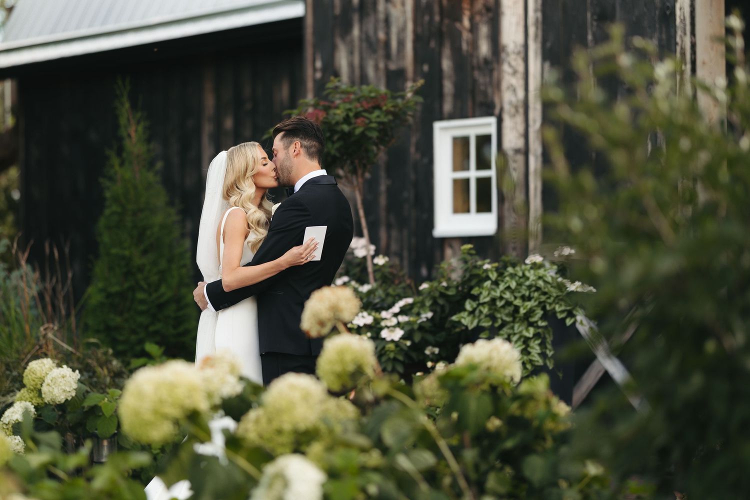 kiss of bride and groom after private vows at black barn