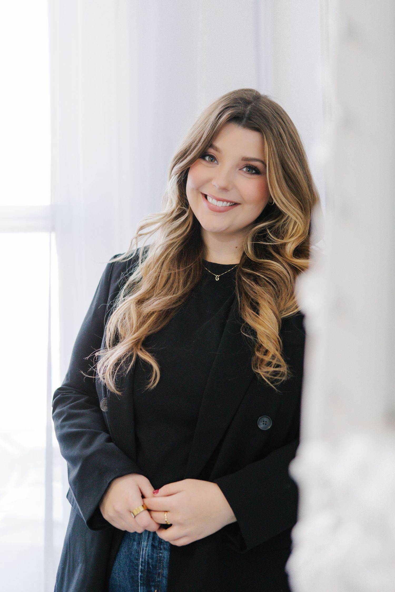 Professional portrait in a black turtleneck sweater against a bright white background.
