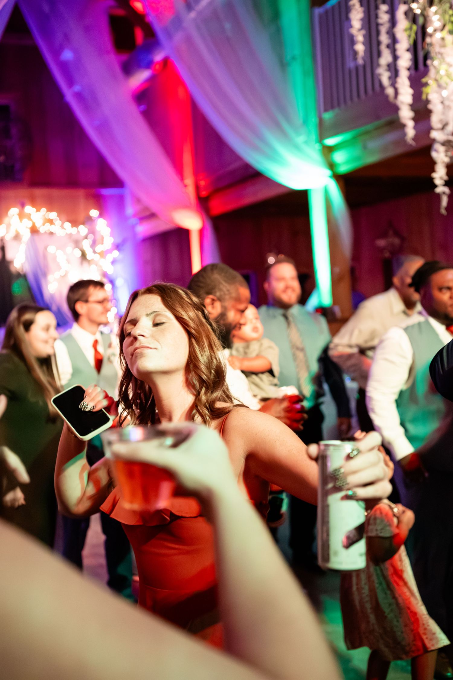 Wedding reception dance floor with colorful purple and green lighting effects.