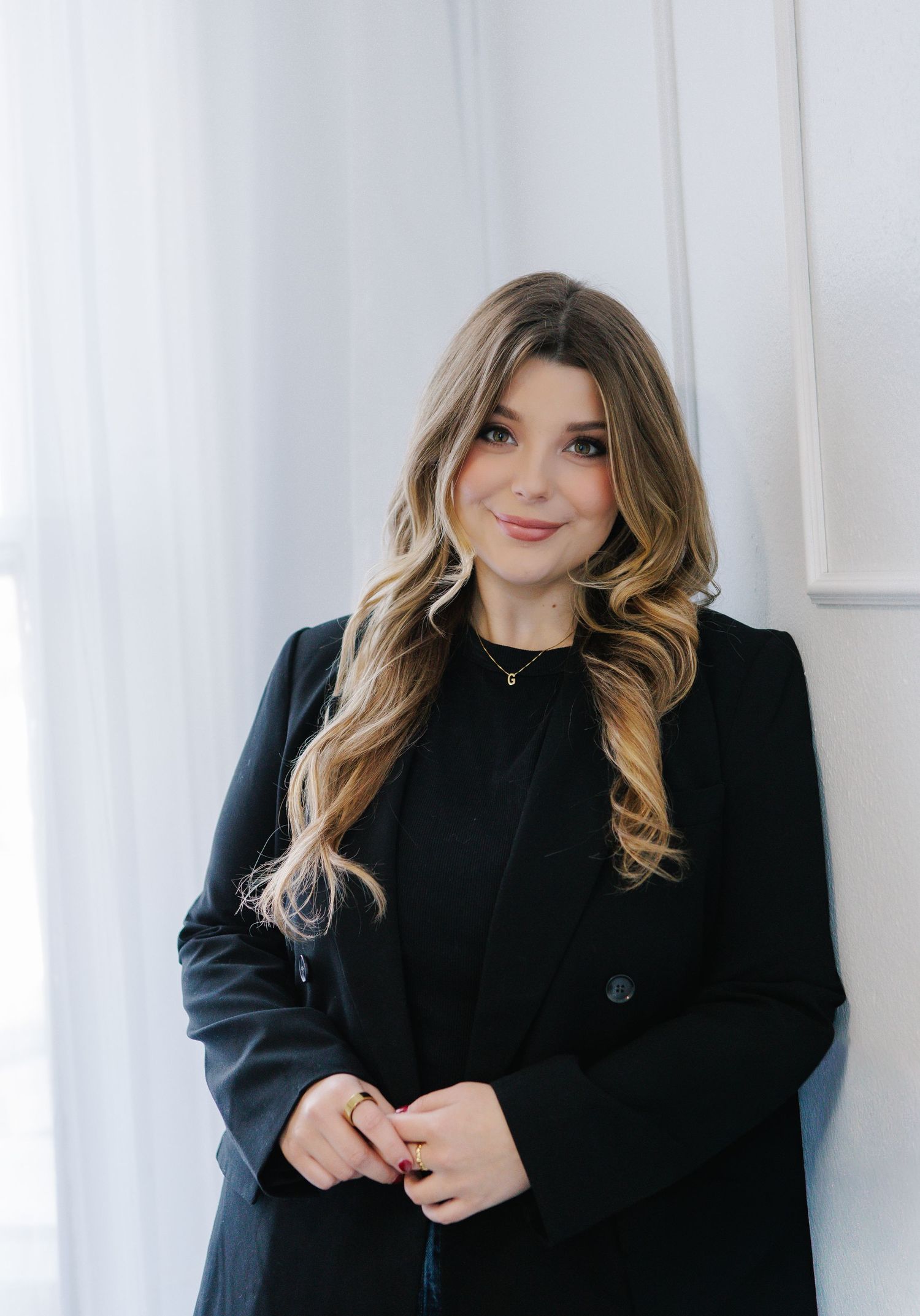 Studio portraits featuring person in black coat against white background.