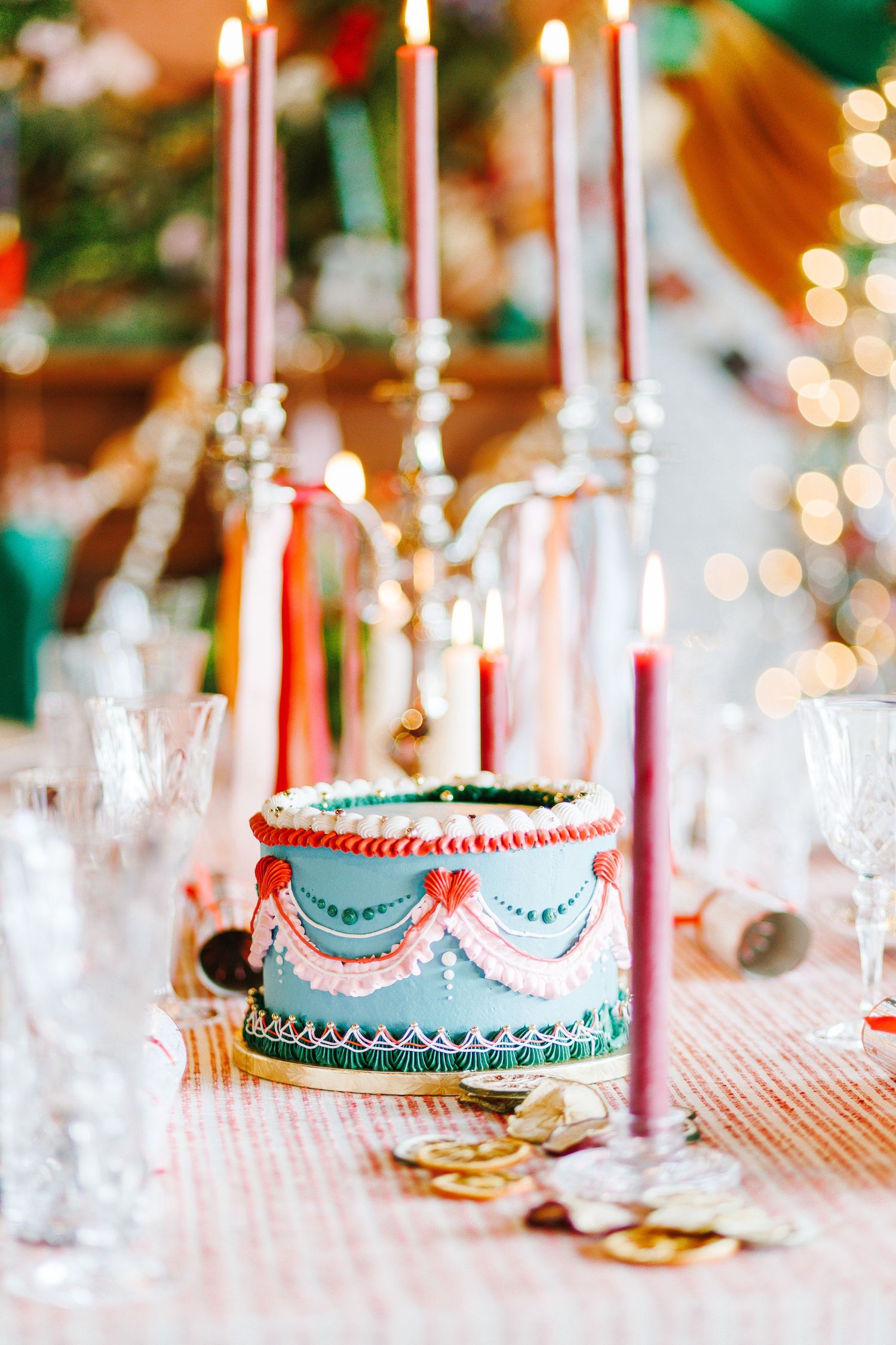 Elegant birthday cake with candles and festive table decorations.