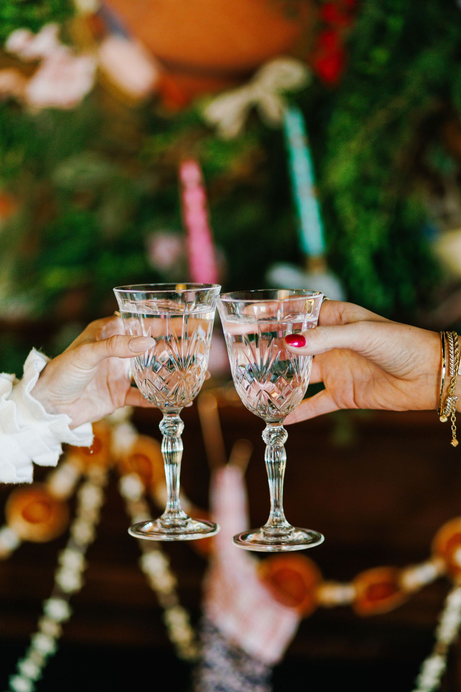 Crystal glasses clinking together in a celebratory toast against a festive background.