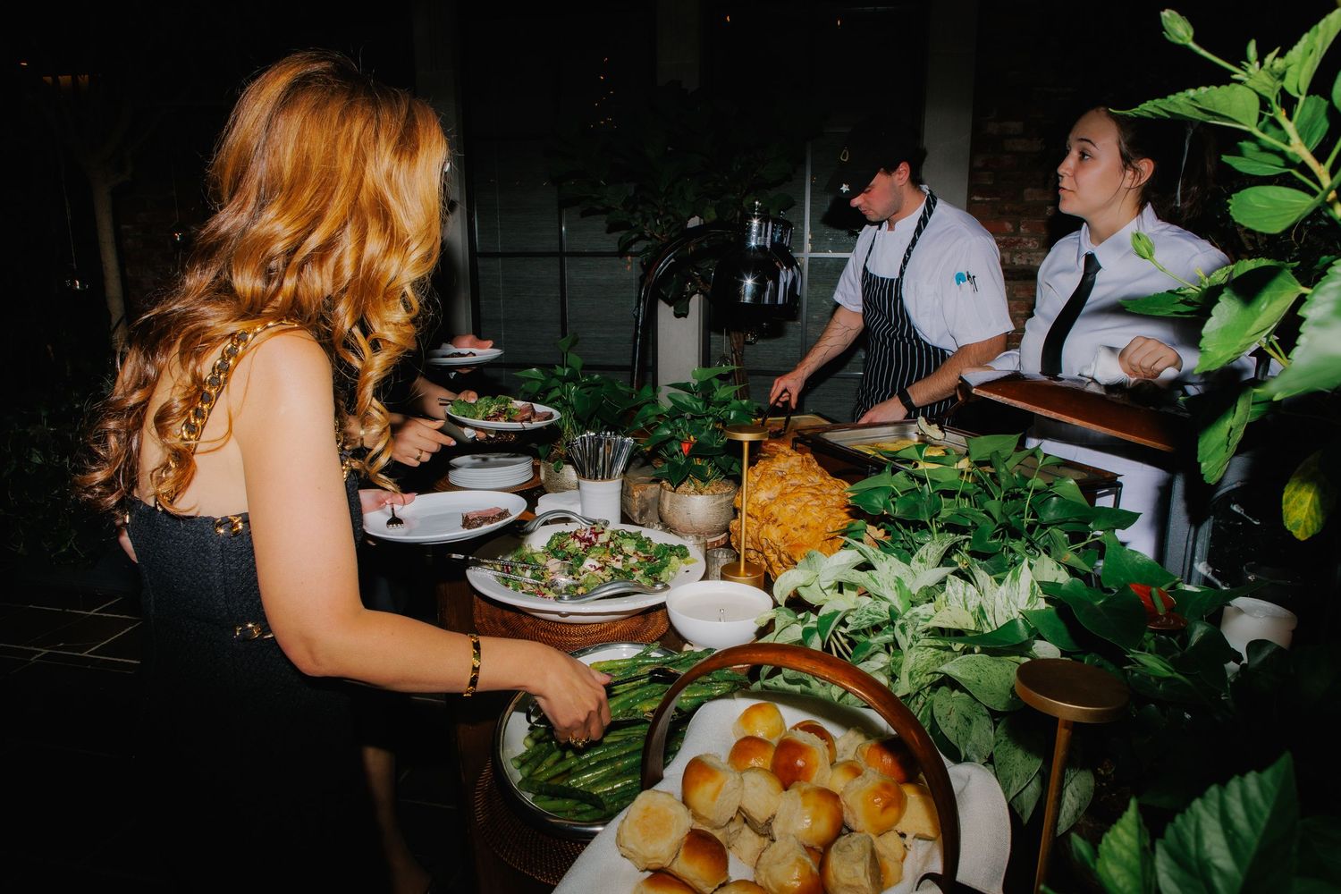Elegantly plated appetizers and hors d'oeuvres displayed on wooden serving boards at an upscale event.