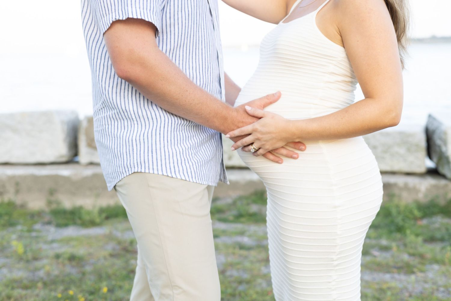 Romantic beach photoshoot featuring a couple in matching casual white and striped attire.
