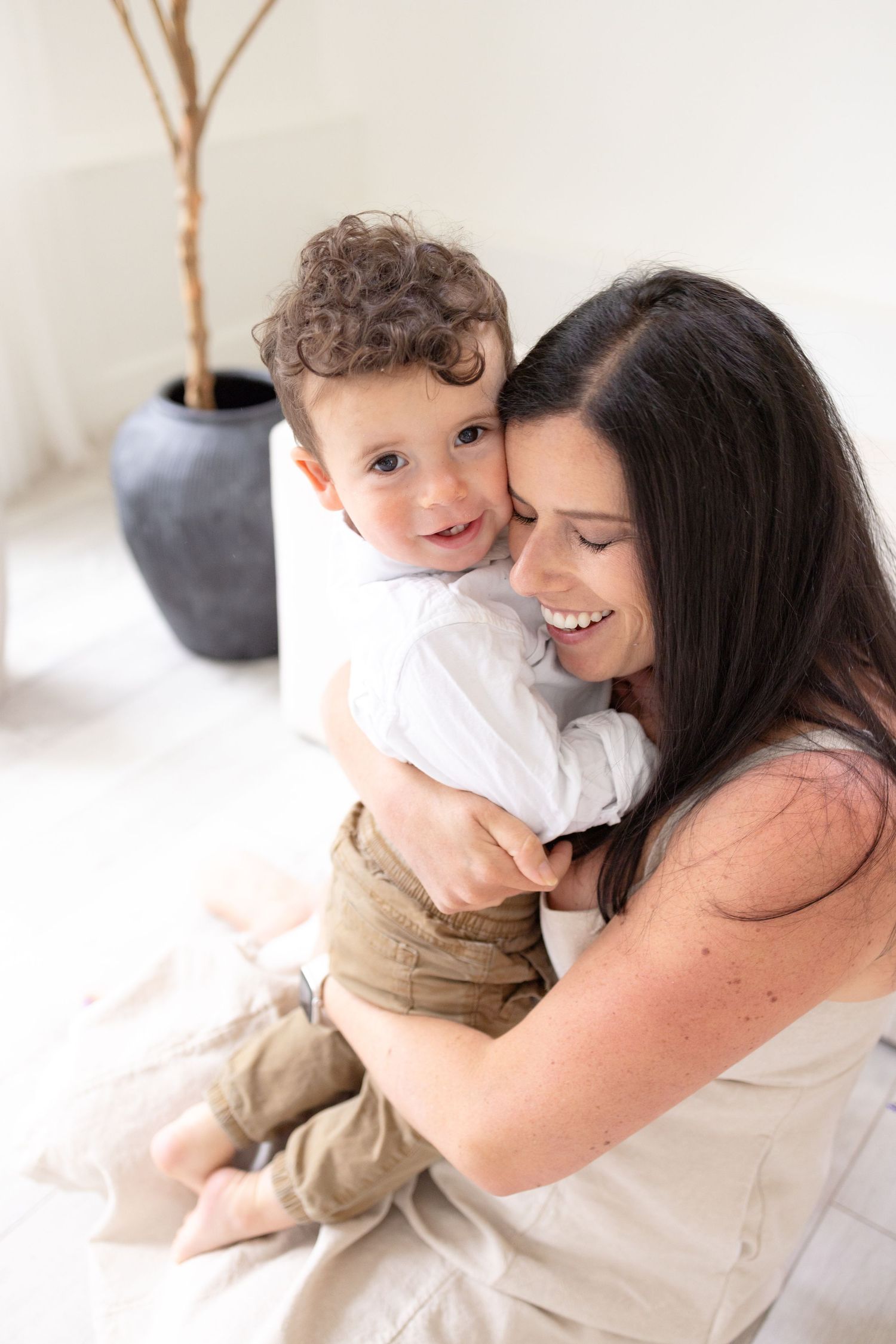 Sweet candid moment captured in bright white studio setting.