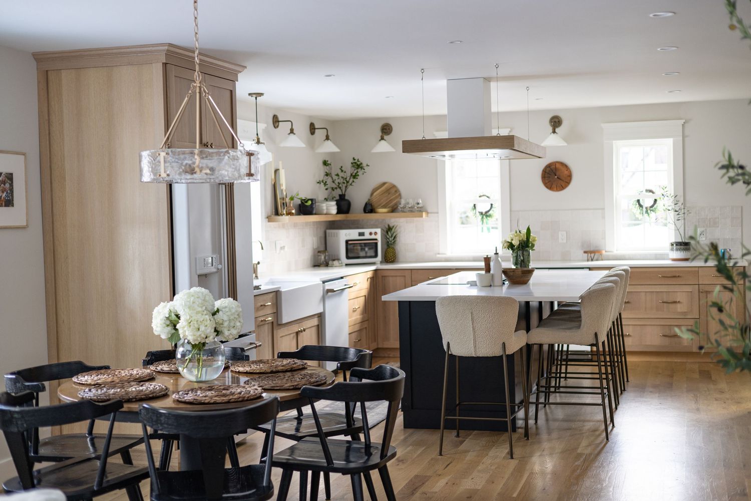 Modern farmhouse kitchen and dining area with natural wood elements and black accents.