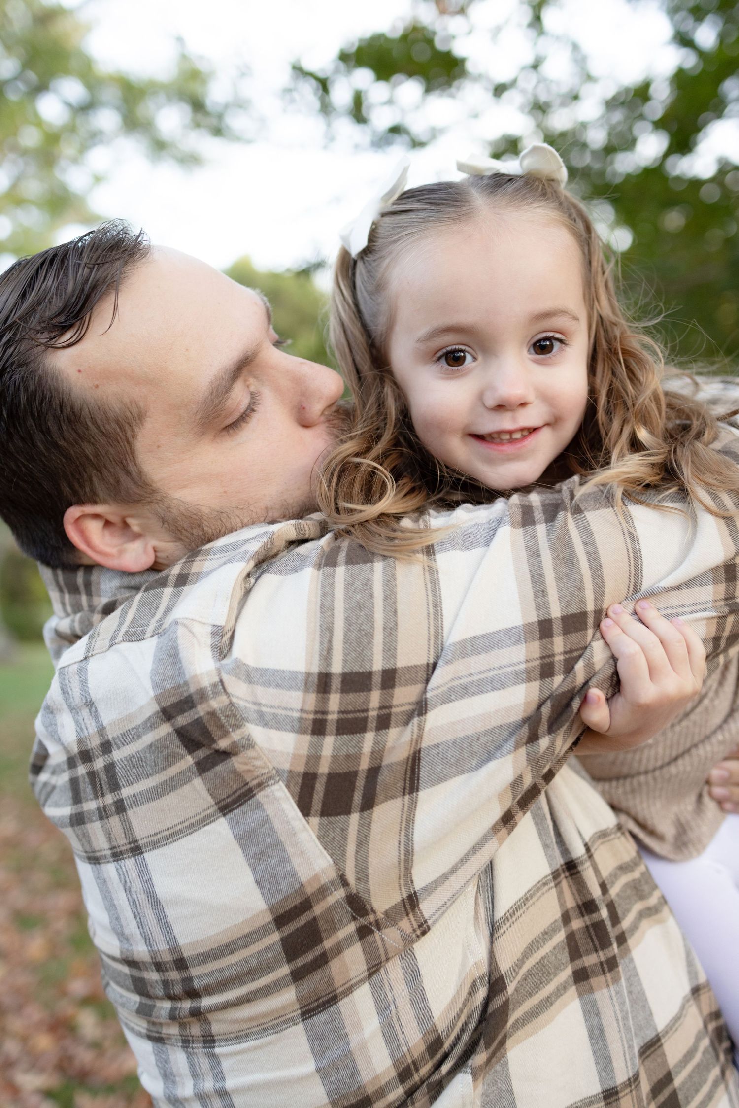 Playful family moments wrapped in plaid blanket during fall photoshoot.
