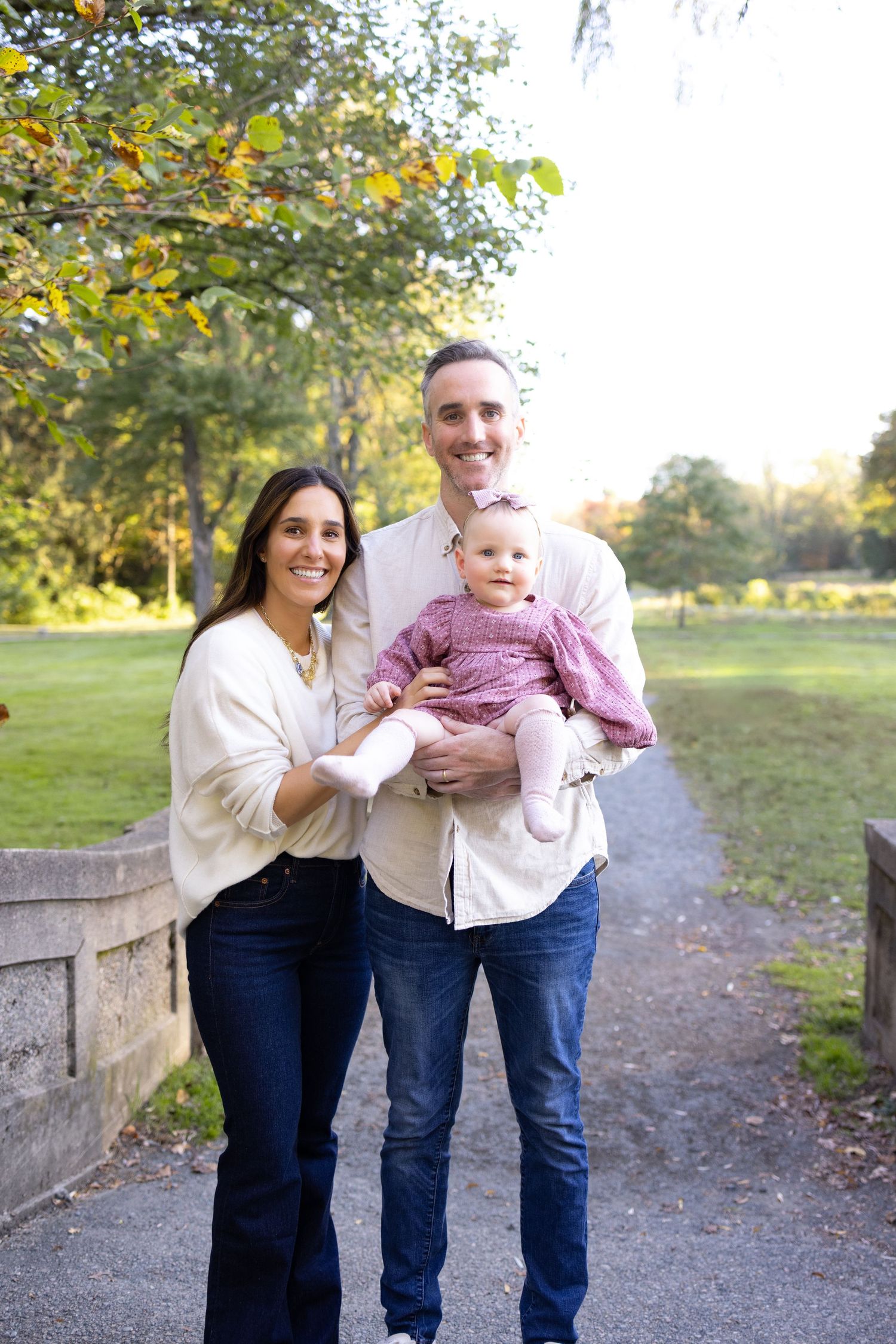 Playful outdoor family photos taken on a path surrounded by autumn trees.