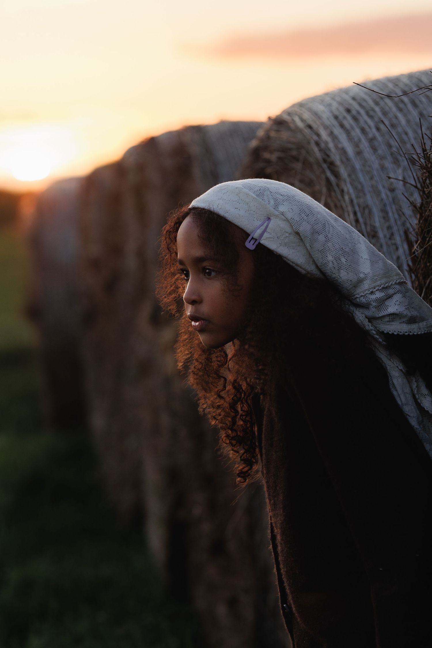 Candid portrait of a child outdoors at sunset during a family photography session.
