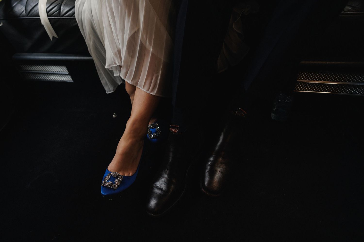 Close-up wedding detail of a bride's blue shoes beneath her wedding dress.