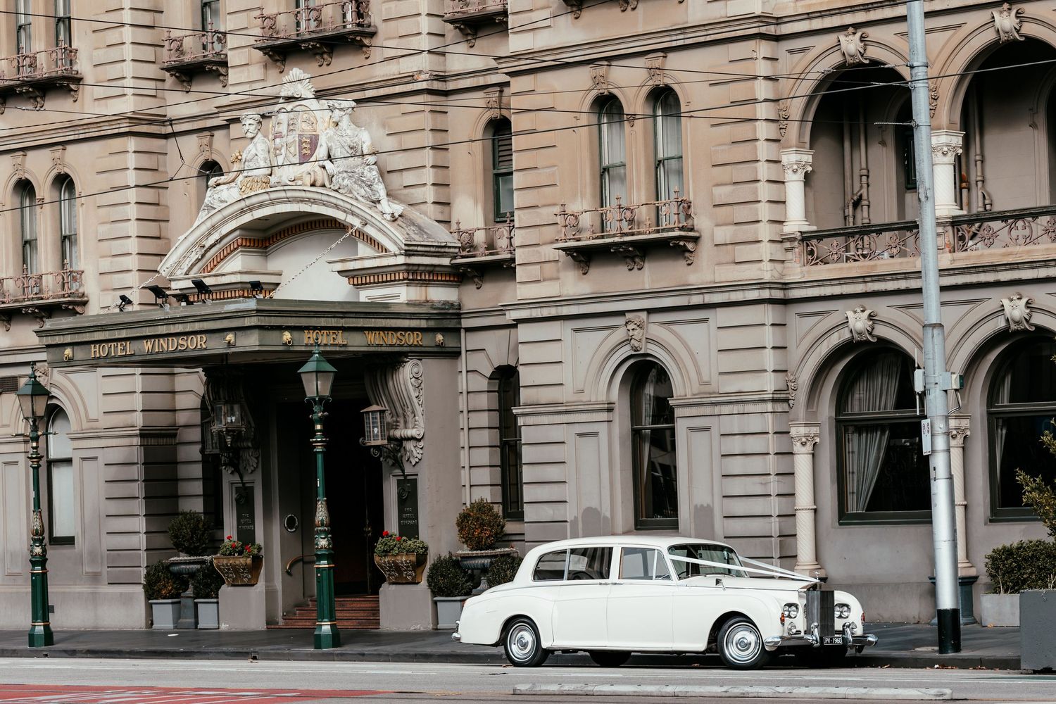 Classic wedding car parked outside a historic Melbourne building.