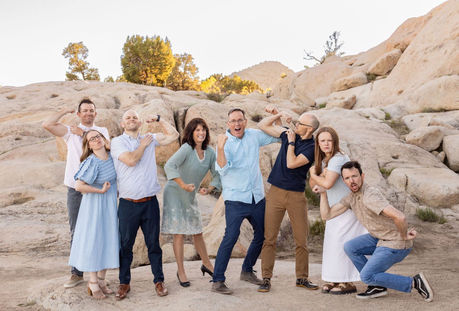 A mom, dad, and their grown up kids doing silly poses during an Extended Family shoot at Three Peaks.
