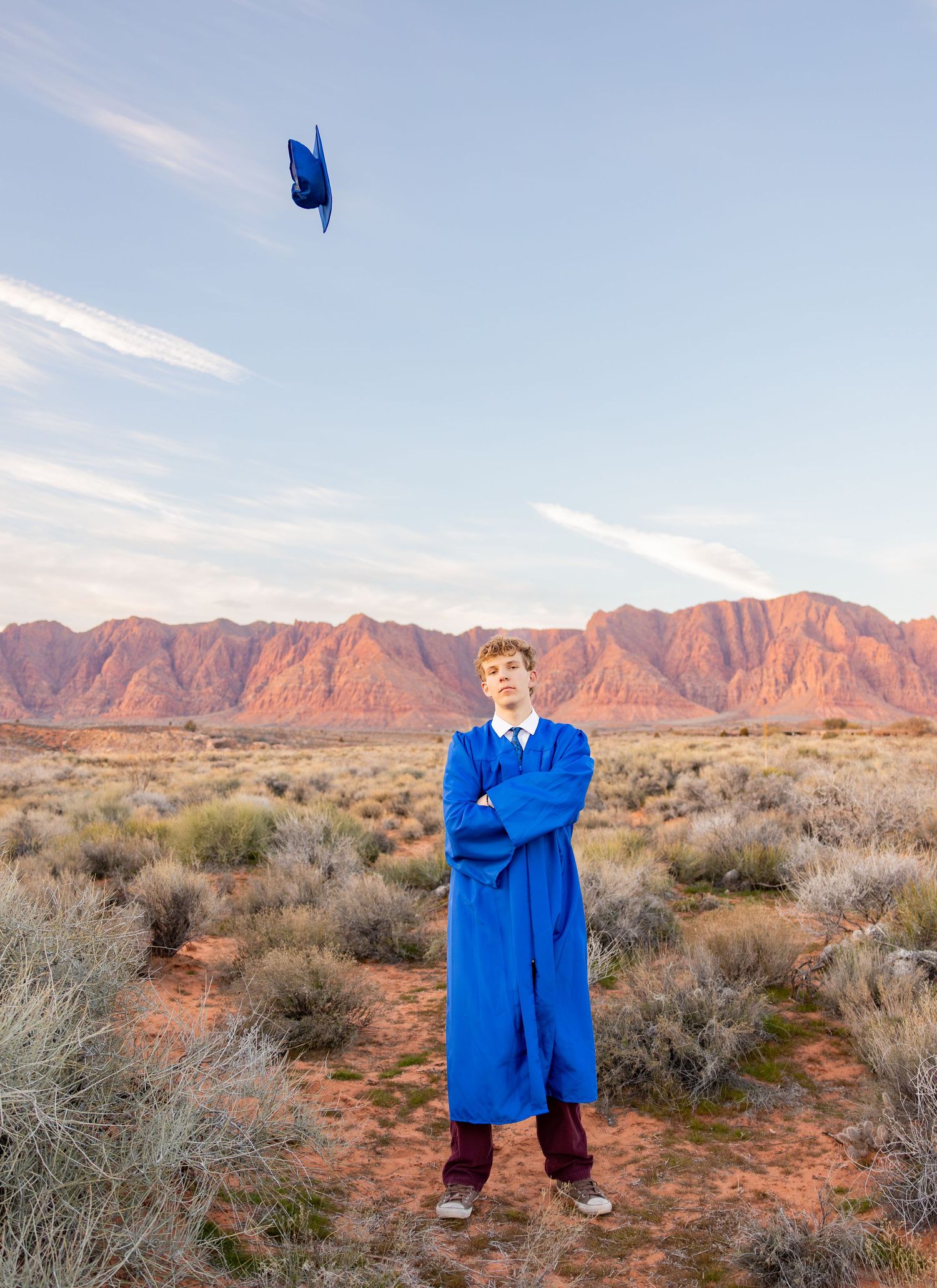A senior graduate threw his graduation cap into the air in front of the stunning red rock mountains in Saint George, Utah.