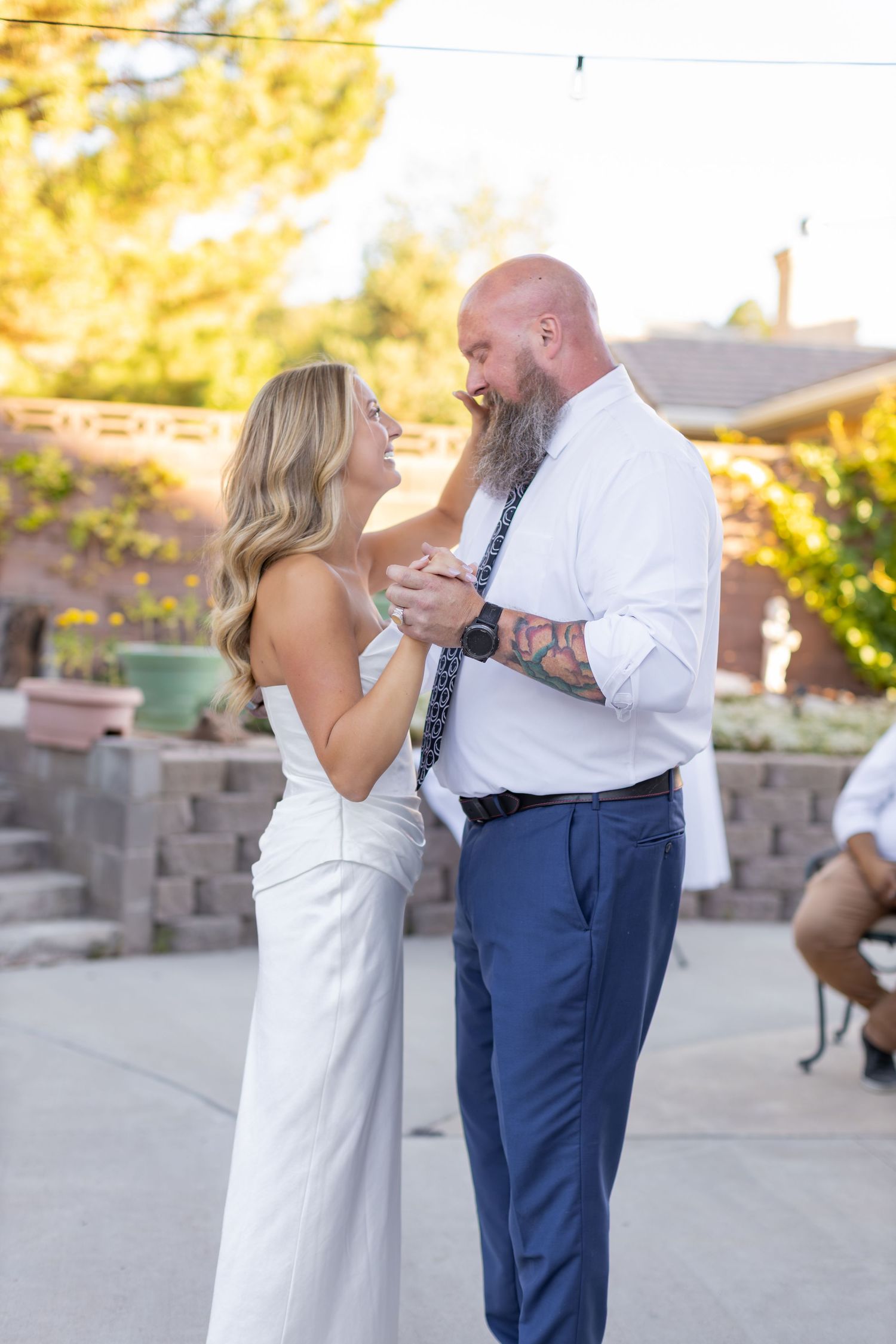 A bride wiping tears off her father's cheek during their dance at her outdoor wedding reception in Southern Utah.