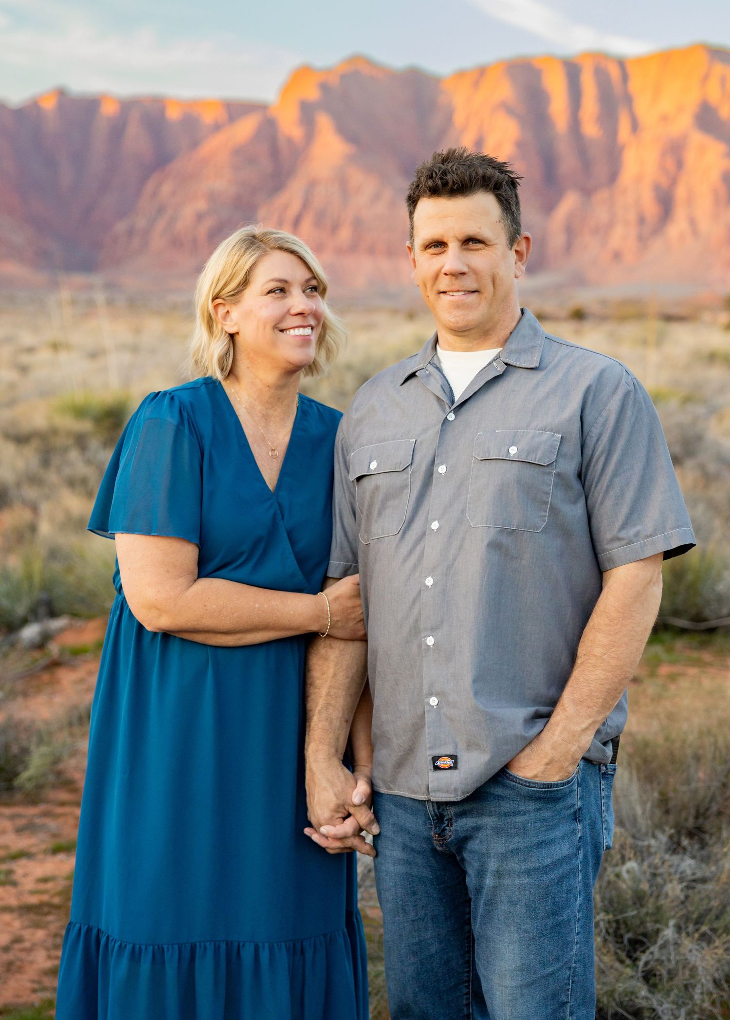 A mom stares lovingly at her husband in front of Southern Utahs red rocks.