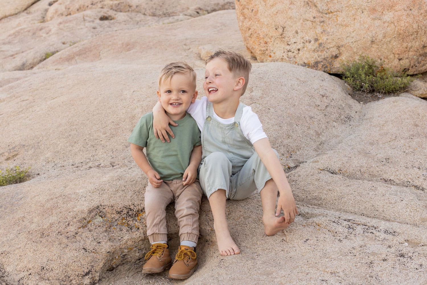 Two brothers laughing at each other during a family photoshoot in Cedar City, Utah.