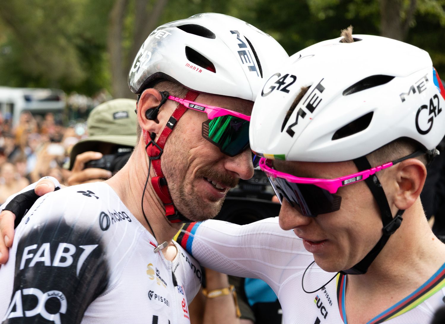 Row of cyclists wearing white helmets and racing gear at a competitive event.