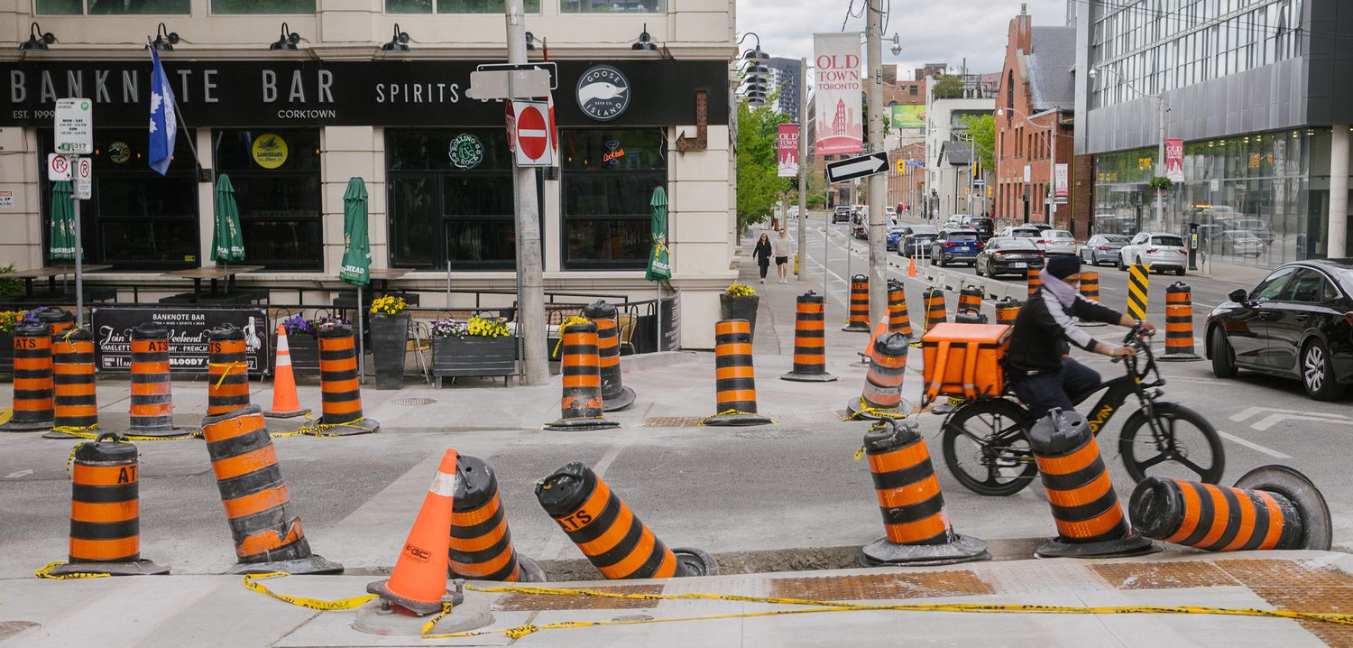 Street lined with orange construction barriers and traffic cones.