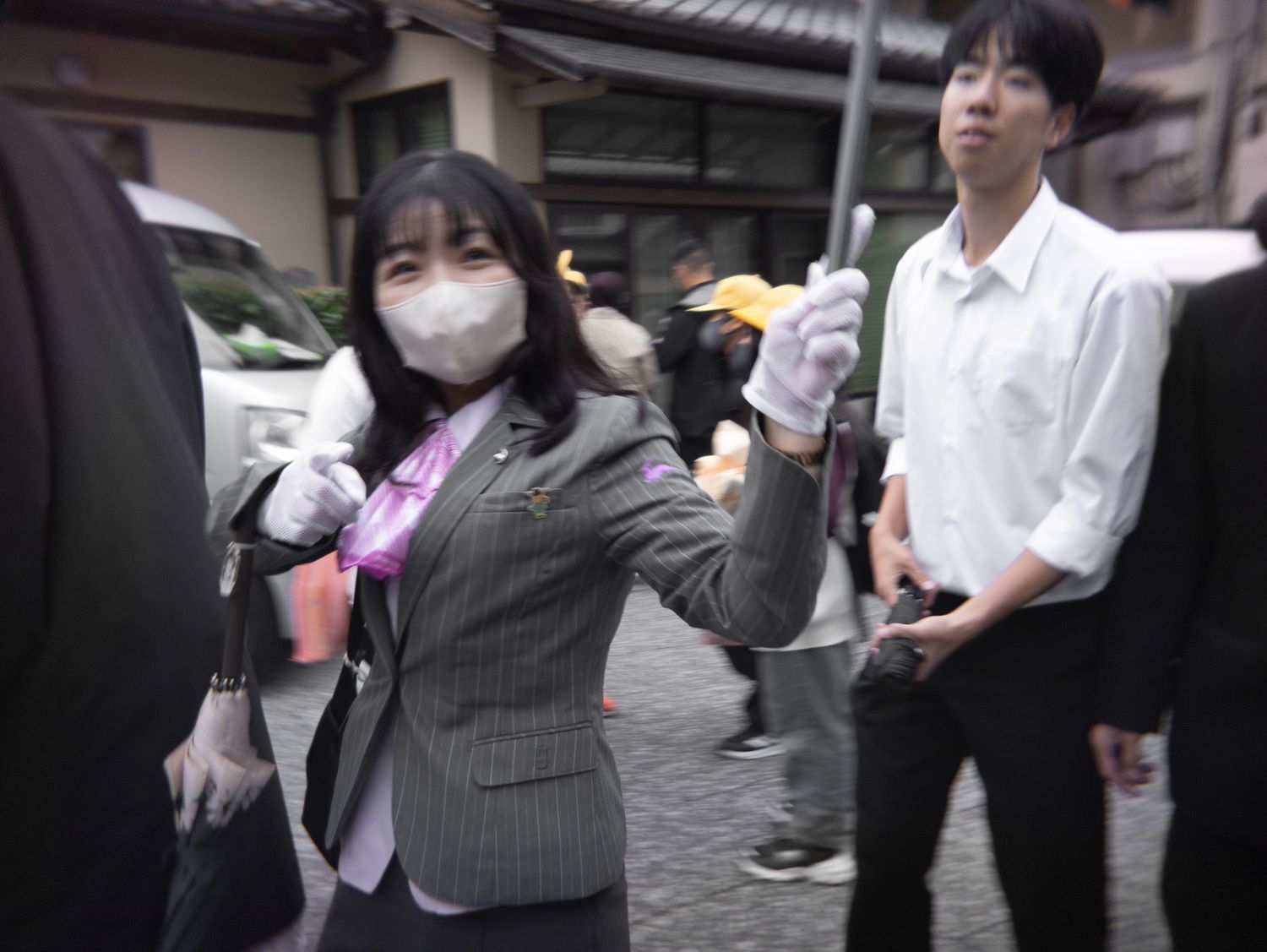 People walking on a busy street in Japan wearing face masks.