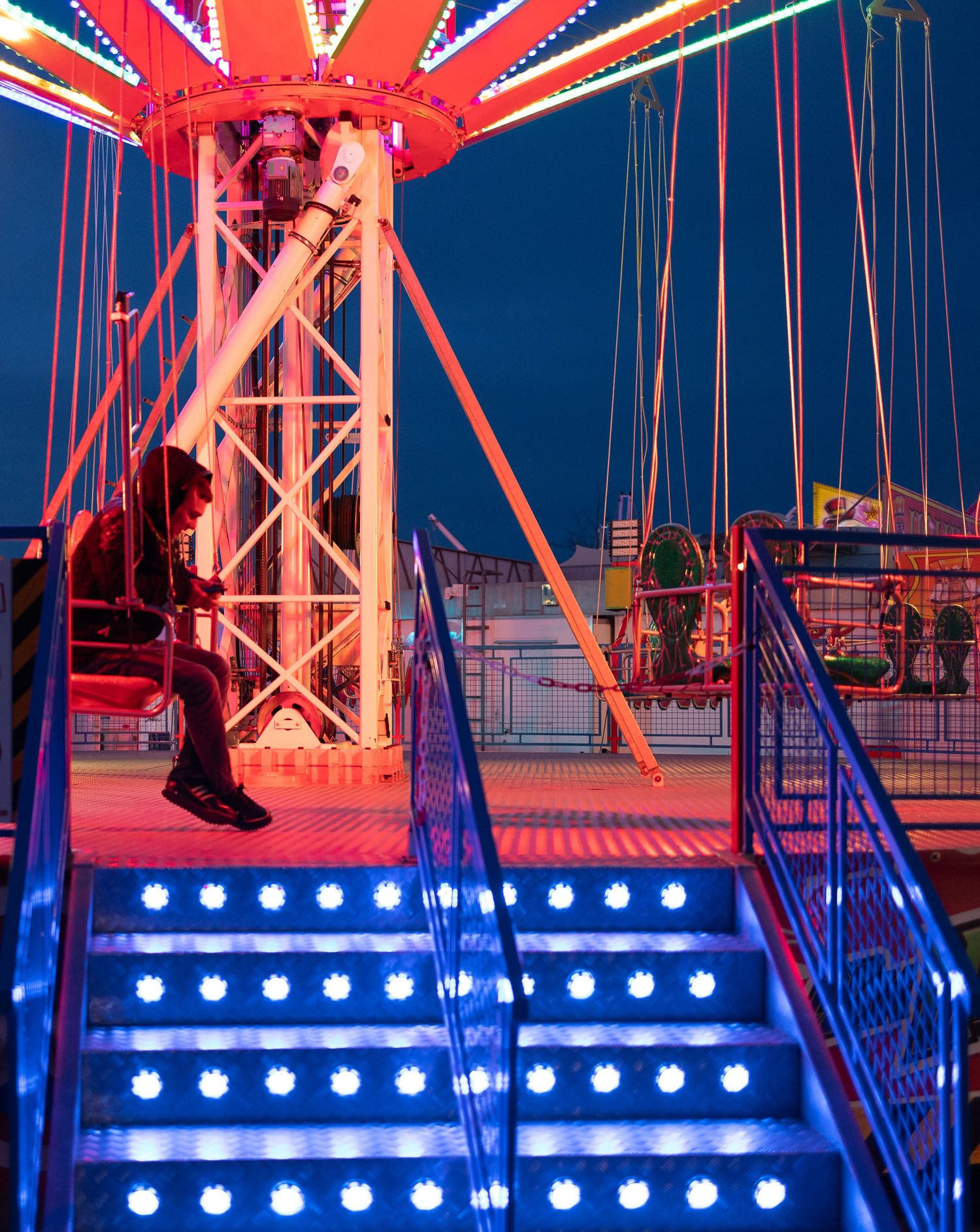 Illuminated blue and red carnival ride steps with bright LED lighting.