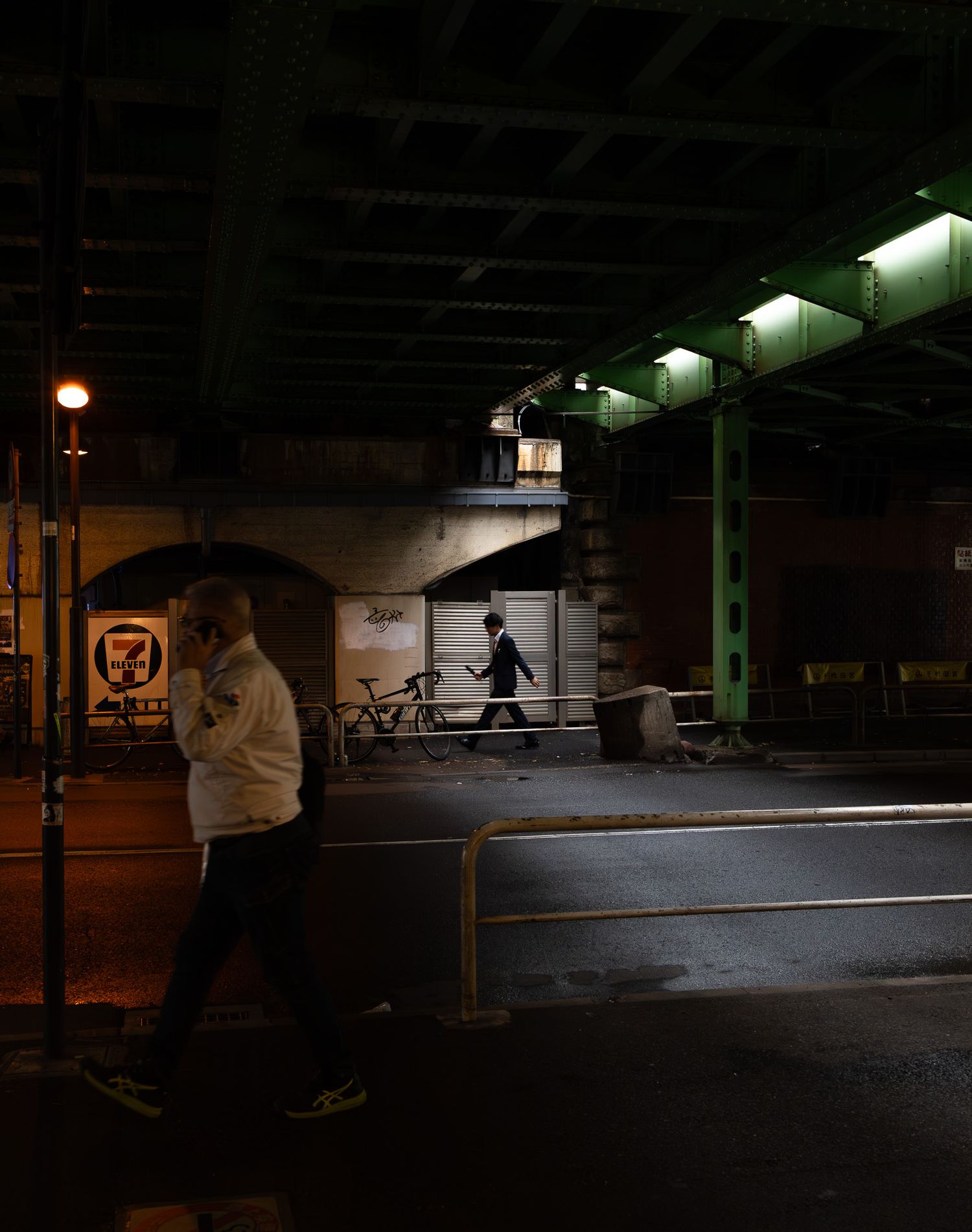 Dimly lit indoor skate park with ramps and obstacles visible under fluorescent lighting.