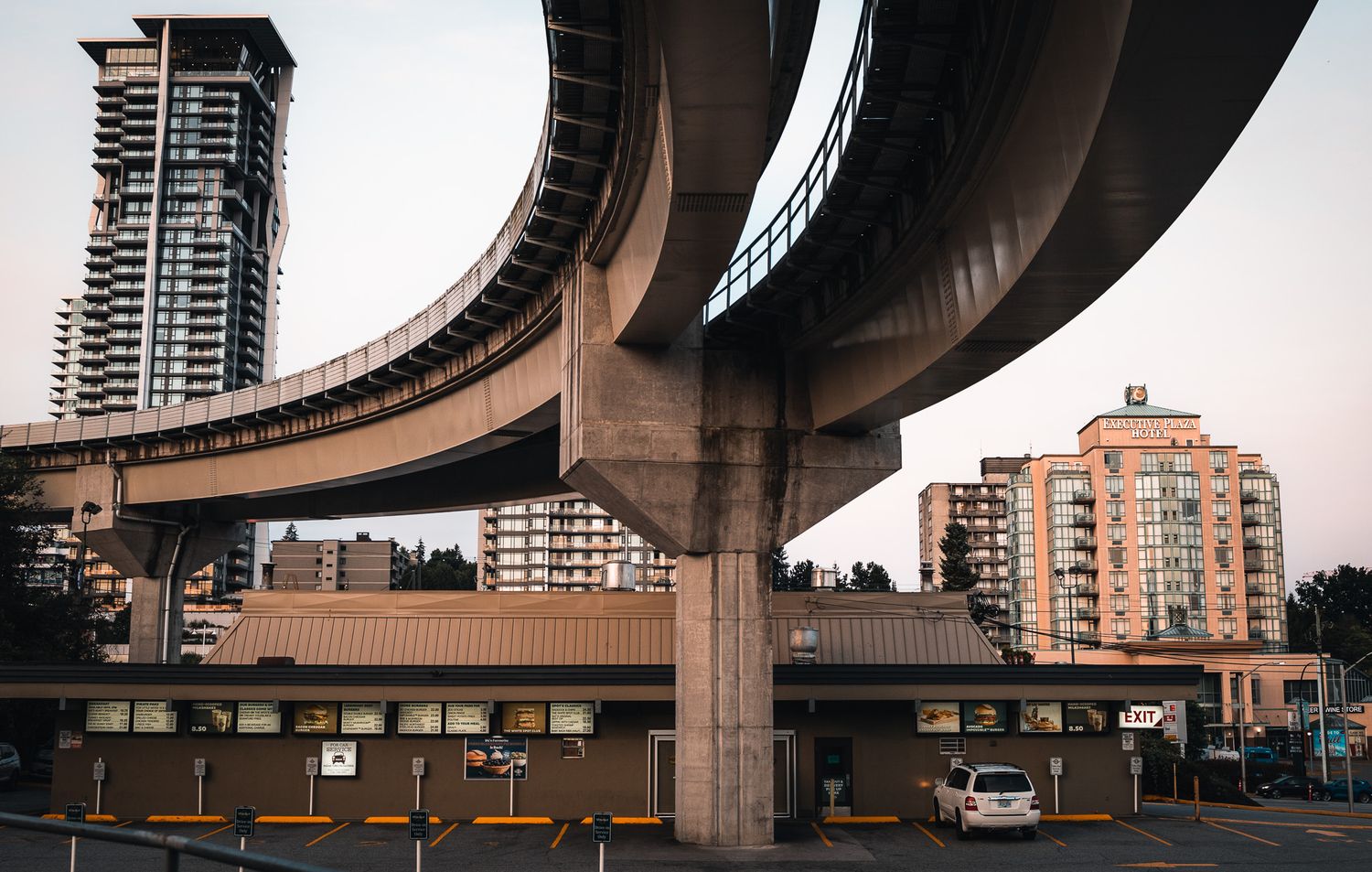 Urban highway overpass with concrete pillars and buildings in panoramic view.