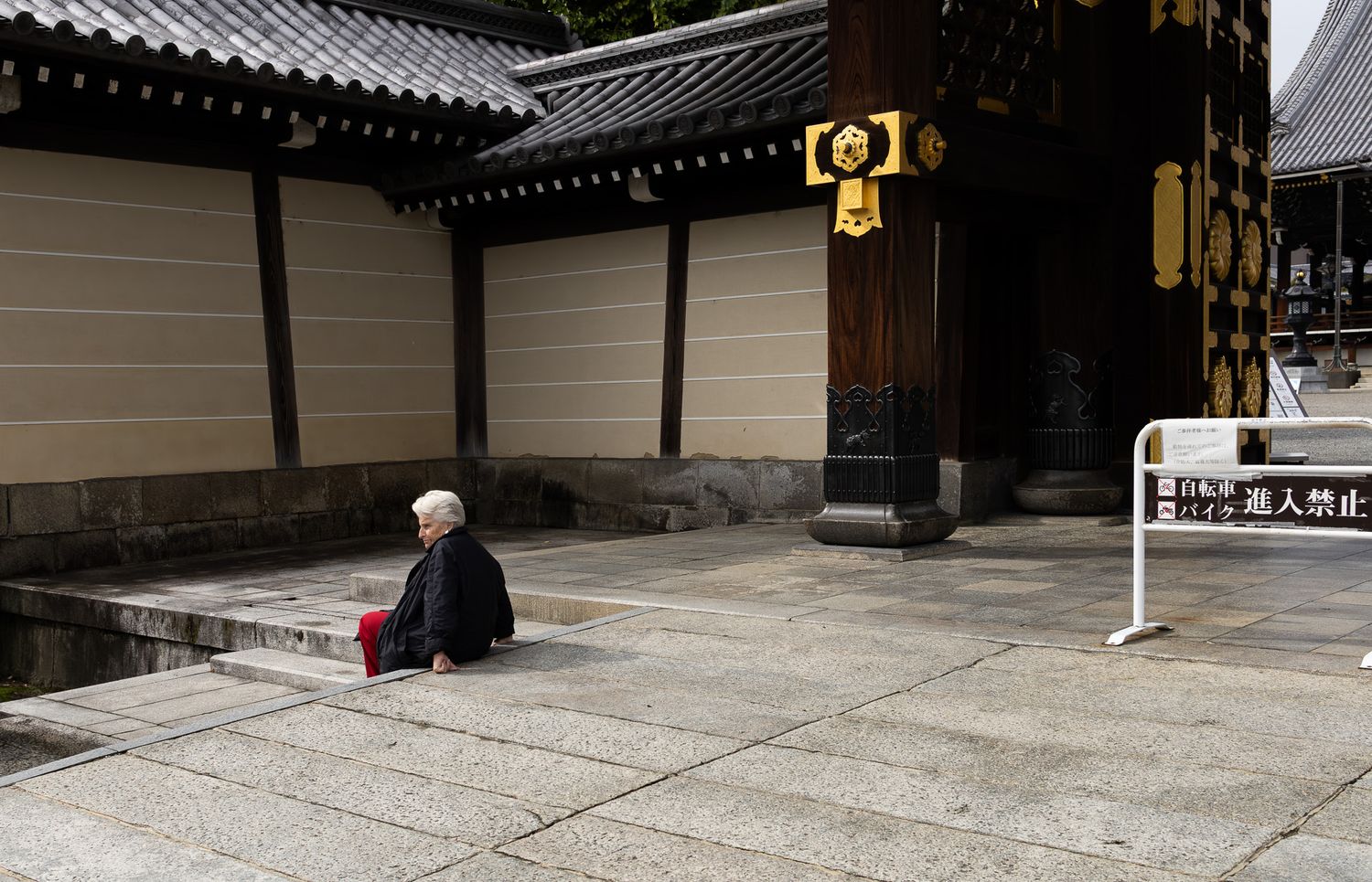 Traditional Japanese temple entrance with ornate roof architecture and stone pathway.