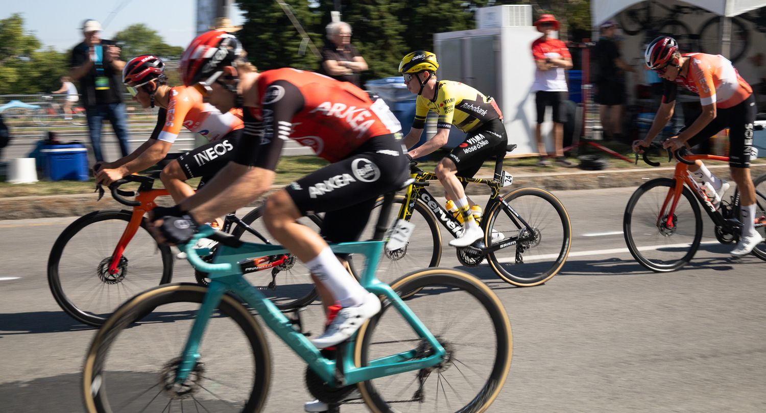 Professional cyclists racing at high speed during a competitive road cycling event.