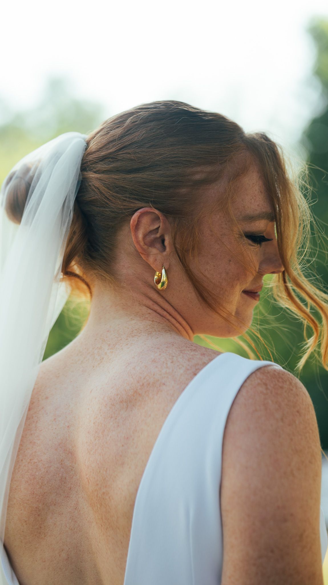 Close-up detail of bride's veil and hair against natural outdoor backdrop.