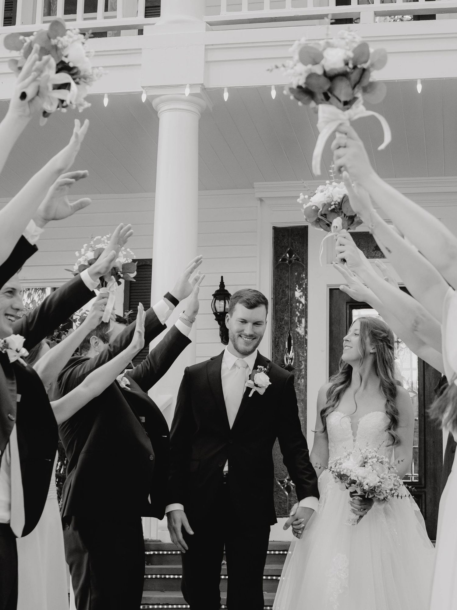 Black and white wedding celebration sequence with guests raising arms in joy.