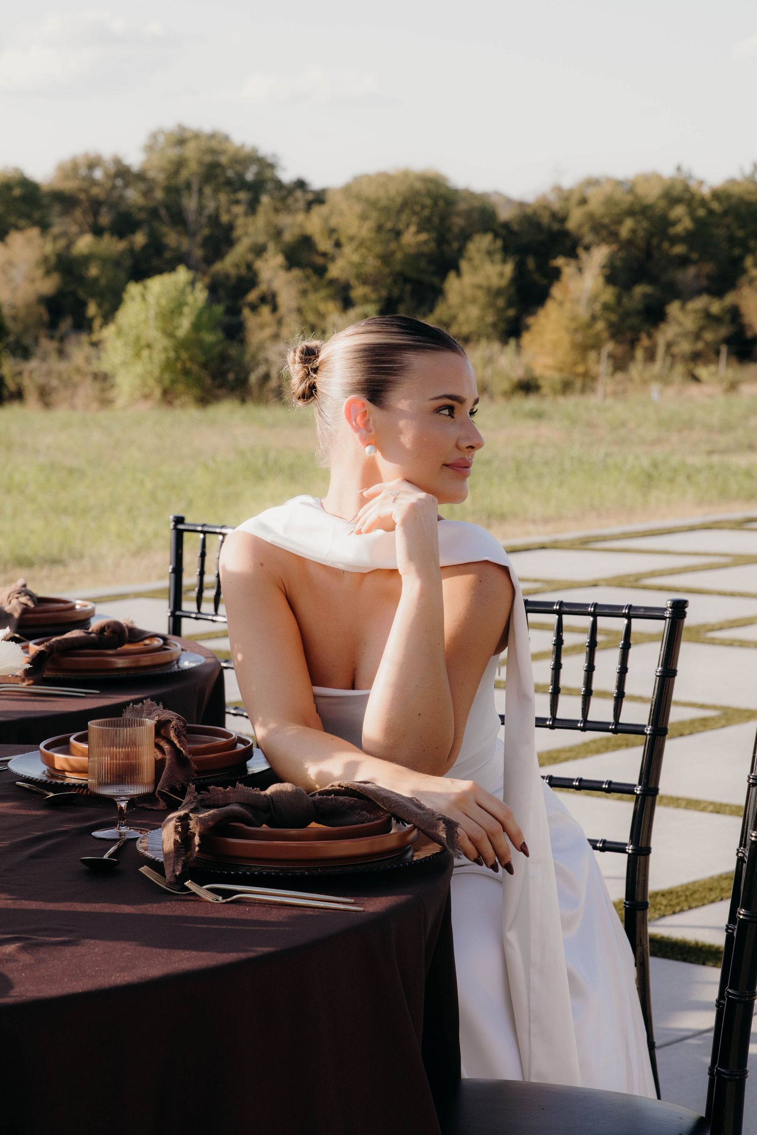 A sequence of photos showing someone in a white dress seated at an elegantly set table with brown place settings outdoors.