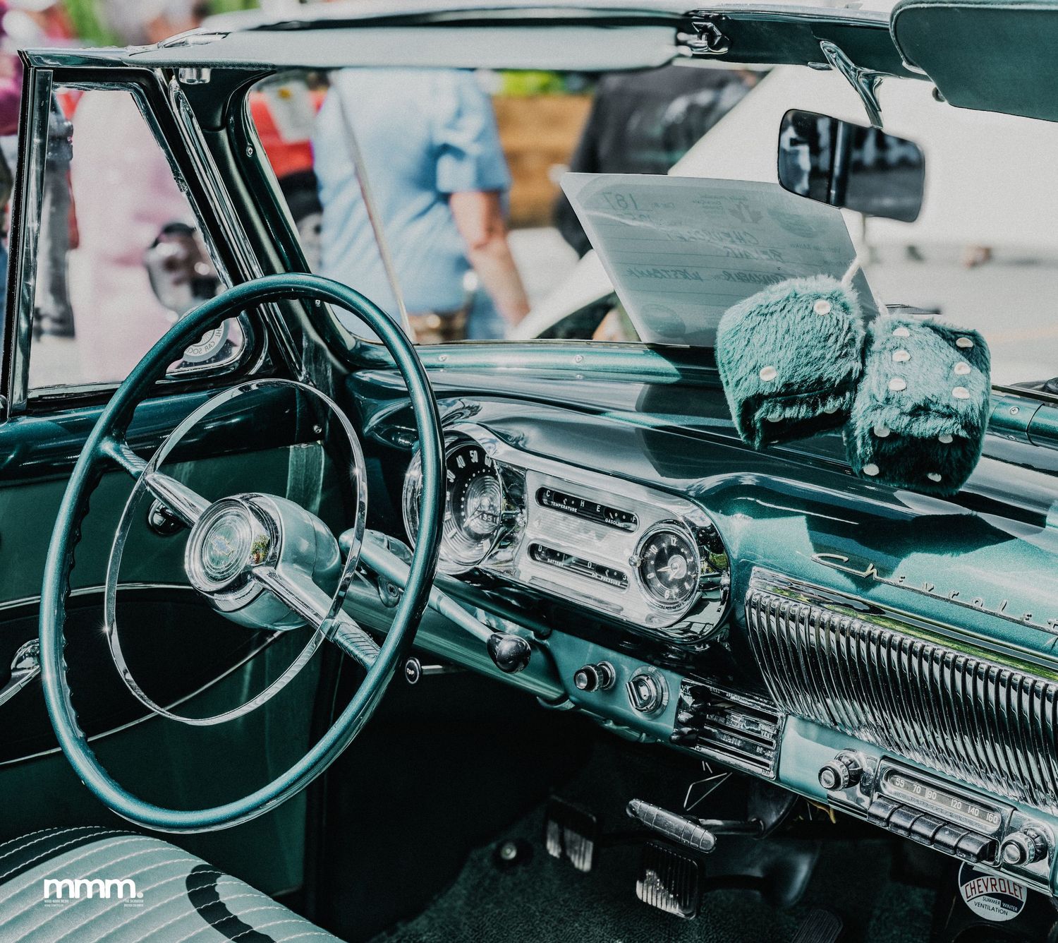 Vintage classic car interior with retro dashboard, steering wheel, and chrome details.