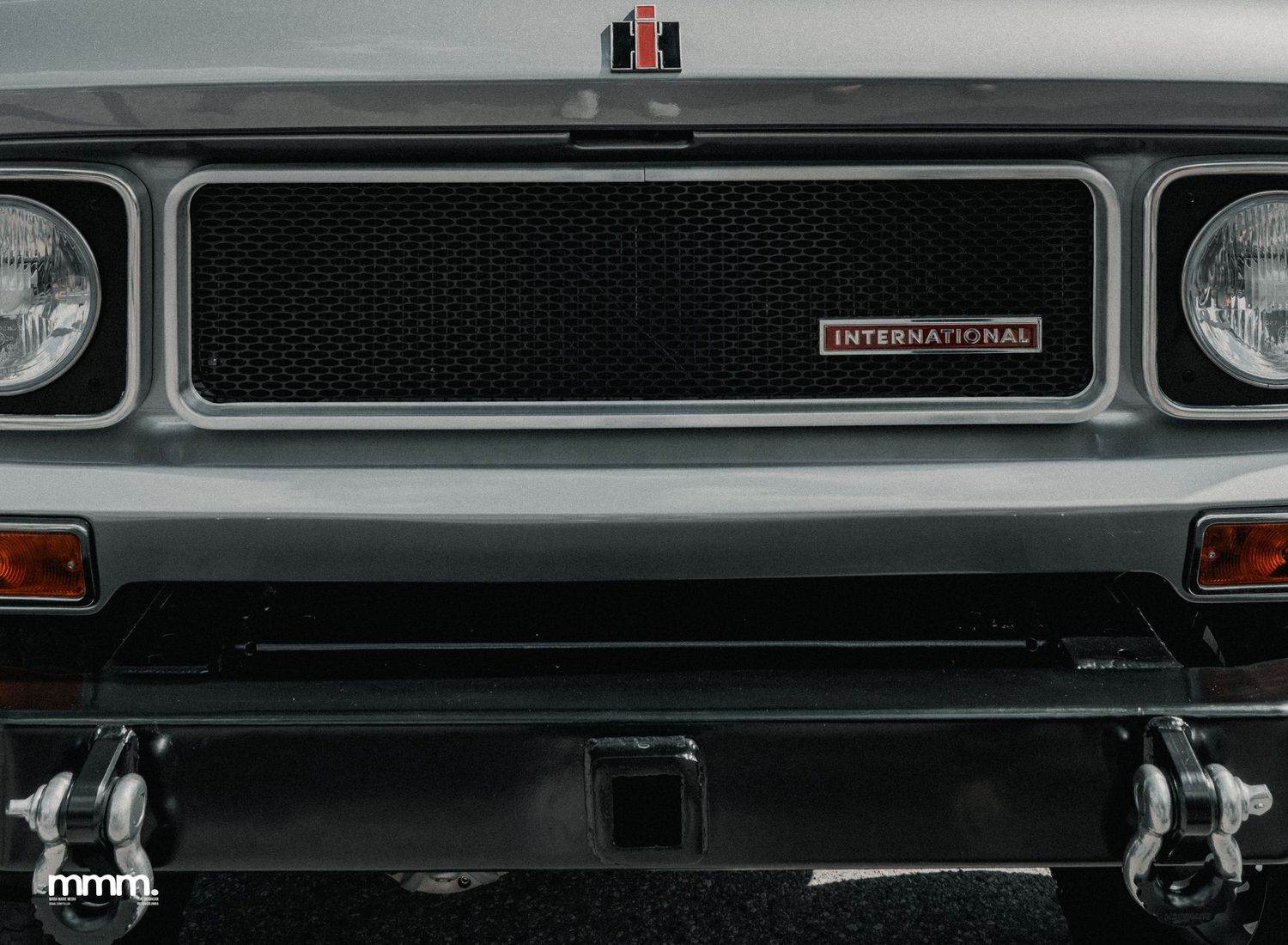 Silver International Scout front grille with black mesh and badge.