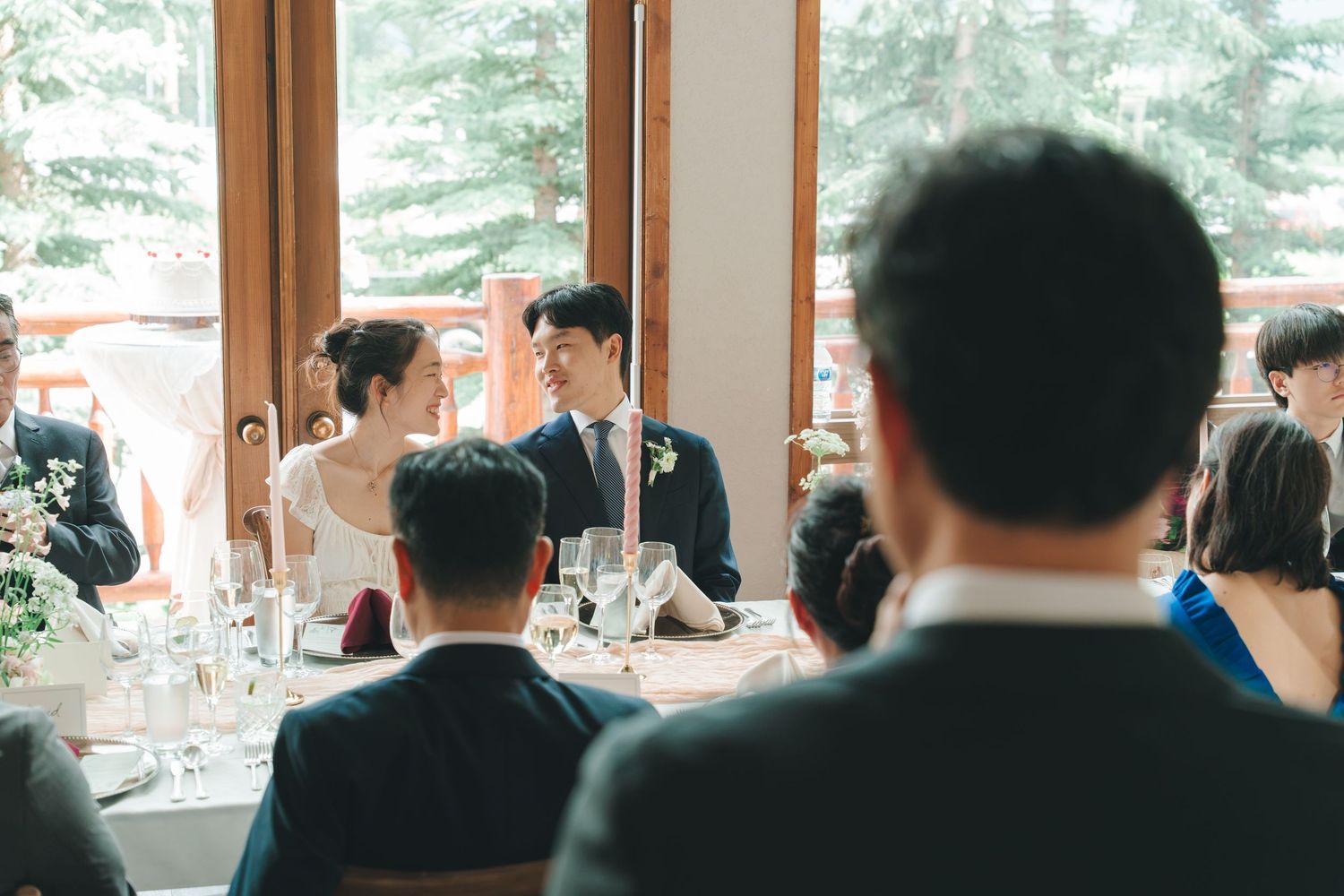 Bride and groom sharing a romantic moment at the sweetheart table during their intimate wedding reception.
